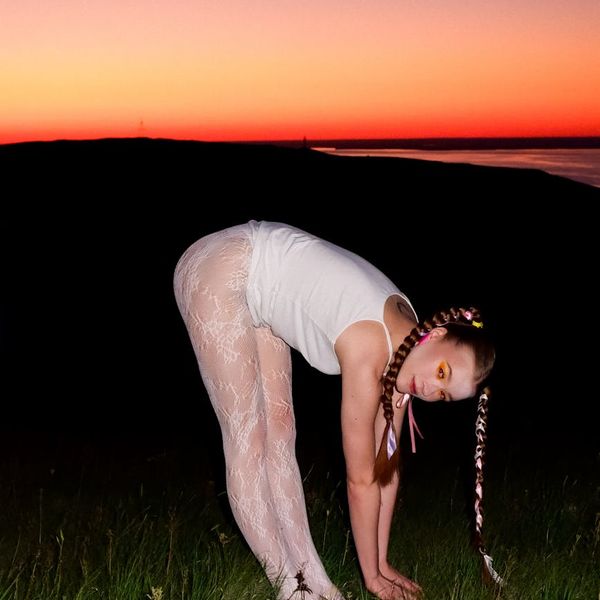 Person stretching gently outdoors with a calm expression.